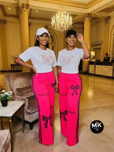 Deux modèles portant un t-shirt blanc et un pantalon fuchsia à nœuds noirs